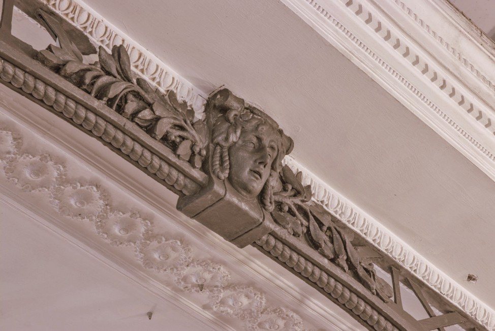 Studio Liberty — mascherone in stucco e capriata in ferro del soffitto storico