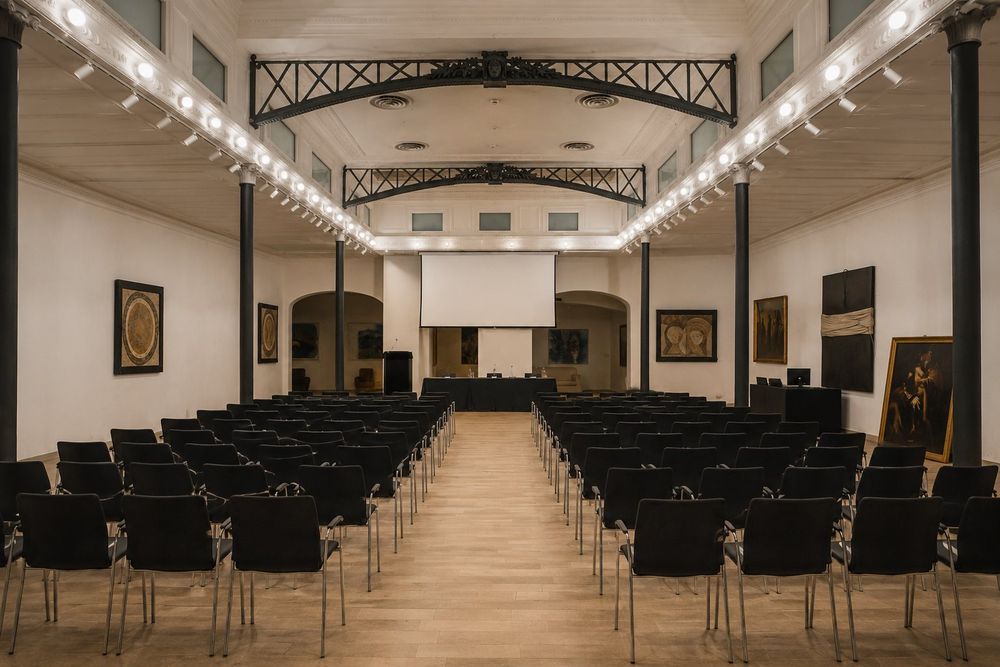 Studio Liberty — platea con tavolo dei relatori e schermo di proiezione
