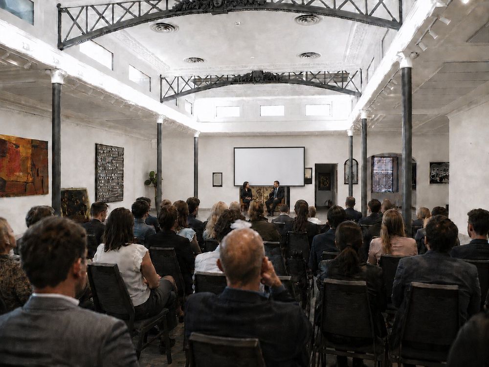 Studio Liberty — dialogo tra due relatori davanti allo schermo con sala piena