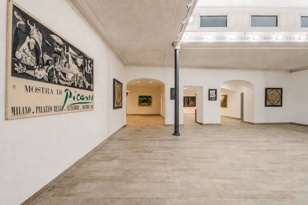 Studio Liberty — sala libera con il manifesto della mostra di Picasso e i passaggi ad arco