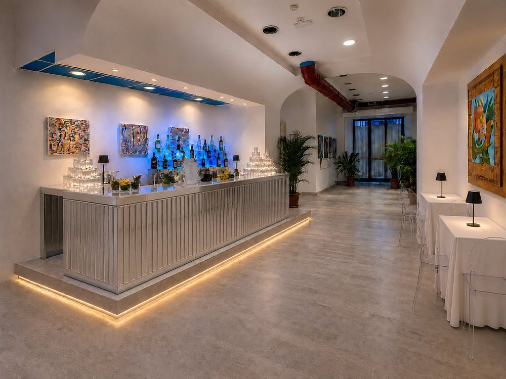 Studio Liberty — bancone bar in acciaio con illuminazione blu nel foyer