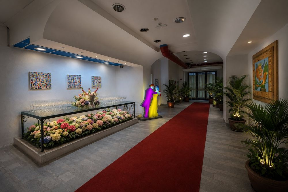 Studio Liberty — ingresso con tappeto rosso e tavolo di benvenuto fiorito